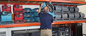 Technician Loading Water Damage Remediation Gear For Residential Job Site