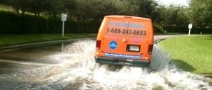Water Damage Restoration Van Driving Down Flooded Street
