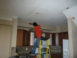 A Technician Repairing Water Damage From a Ceiling Leak 